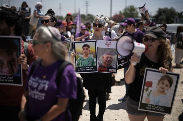 People hold pictures of hostages held by Hamas and children killed by Israeli bombardment in the Gaza Strip at a protest near the Israeli-Gaza border in Sderot, southern Israel, Friday, May 23, 2025.