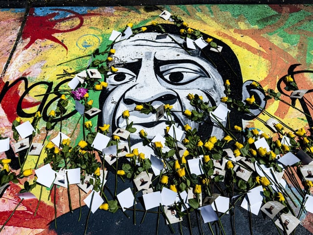 Des roses jaunes et des messages déposés sur une fresque murale à la mémoire de George Floyd, le 23 mai 2025 à Minneapolis, dans le Minnesota