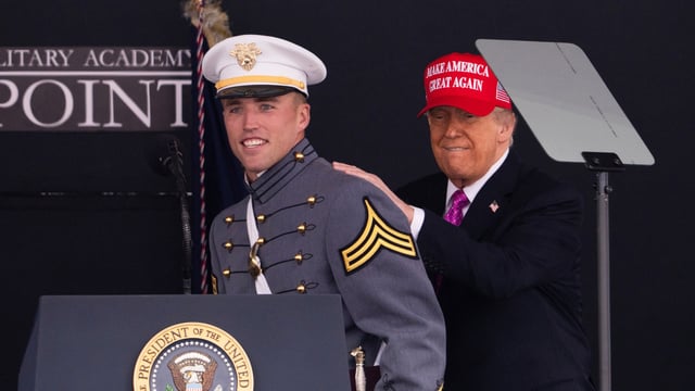 President Donald Trump pats graduating cadet Bryson Daily on the back, who is an American college football quarterback for the Army Black Knights, during the United States Military Academy commencement ceremonies in West Point, N.Y., Saturday, May 24, 2025. (AP Photo/Adam Gray)