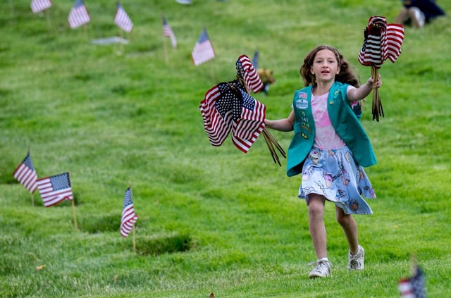 Girl Scout Anna Dunn, 10, of Menifee, runs more flags to her Girl Scout Troop 1916 on Saturday morning, May 24, 2025, while helping place flags as Riverside National Cemetery prepares for Memorial Day. (Photo by Terry Pierson, The Press-Enterprise/SCNG)