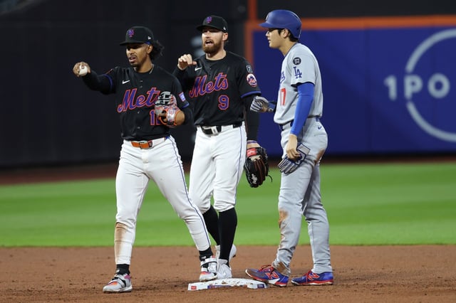 New York Mets shortstop Francisco Lindor, left, and outfielder Brandon Nimmo, center, talk to officials after Los Angeles Dodgers&#39; Shohei Ohtani, right, was declared safe at second base on a hit by Mookie Betts during the third inning of a baseball game Friday, May 23, 2025, in New York. (AP Photo/Pamela Smith)