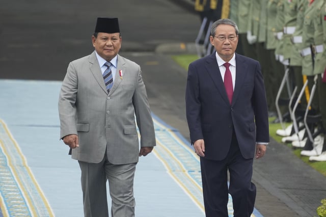 Chinese Premier Li Qiang, right, with Indonesian President Prabowo Subianto, inspects honor guards during the welcoming ceremony ahead of their meeting in Jakarta, Indonesia, Sunday, May 25, 2025. (AP Photo/Achmad Ibrahim)