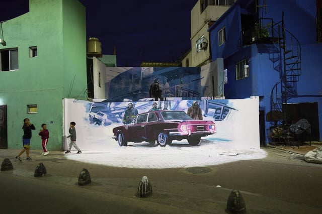 Children hang out next to a promotional mural for the Netflix series "The Eternaut," an adaptation of a classic Argentine sci-fi comic, in Buenos Aires, Argentina, Monday, April 21, 2025. (AP Photo/Rodrigo Abd)