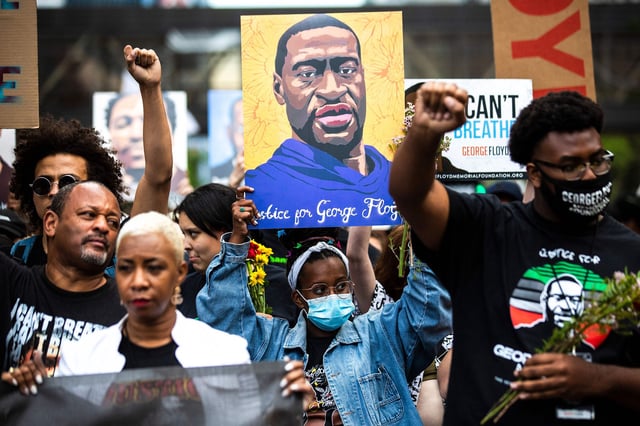 People raise their fists as they march during an event in remembrance of George Floyd in Minneapolis, Minnesota in May 2021.