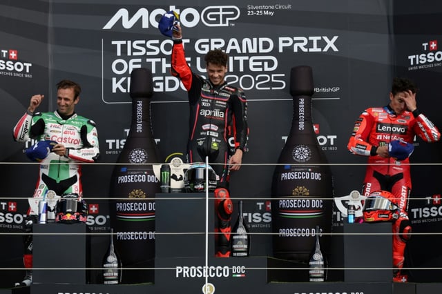 Le podium du GP moto de Grande Bretagne avec de gauche à droite:  le Français Johann Zarco 2e (LCR-Honda), le vainqueur italien Marco Bezzecchi (Aprilia-Racing) et l'Espagnol Marc Marquez (Ducati) 3e, le 25 mai 2025 à Silverstone en Angleterre