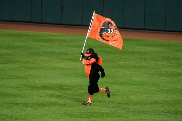 The Oriole Bird runs onto the field with a flag after the Baltimore Orioles defeated the Boston Red Sox 6-2 during a baseball game, Thursday, Sept. 30, 2021, in Baltimore. (AP Photo/Julio Cortez)