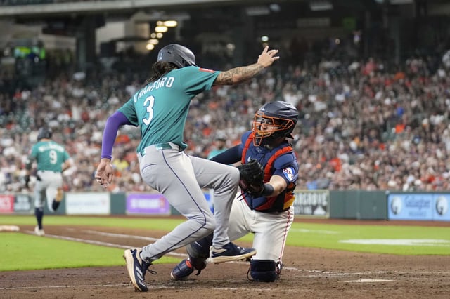 Seattle Mariners&#39; J.P. Crawford (3) is tagged out at home plate by Houston Astros catcher Yainer Diaz (21) during the eighth inning of a baseball game Sunday, May 25, 2025, in Houston. (AP Photo/David J. Phillip)