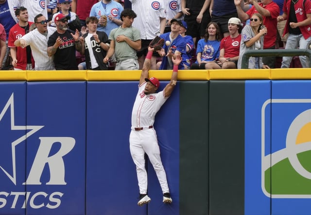Cincinnati Reds right fielder Will Benson leaps for but misses a solo home run hit by Chicago Cubs' Reese McGuire in the second inning of a baseball game, Sunday, May 25, 2025, in Cincinnati. (AP Photo/Carolyn Kaster)