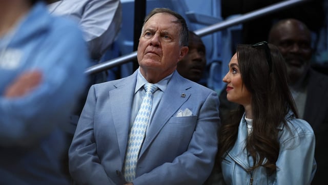 North Carolina Tar Heels football head coach Bill Belichick and his girlfriend Jordon Hudson look on during the first half of the game between the North Carolina Tar Heels and the Duke Blue Devils at Dean E. Smith Centre on March 08, 2025, in Chapel Hill, North Carolina.