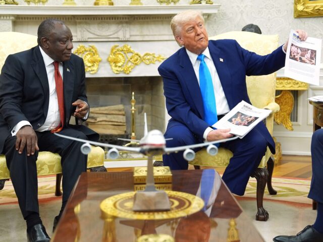 President Donald Trump shows documents as he meets South Africa's President Cyril Ramaphosa in the Oval Office of the White House, Wednesday, May 21, 2025, in Washington. (AP Photo/Evan Vucci)