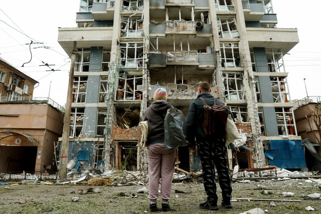 Residents look at an apartment building that was damaged in a Russian drone strike, amid Russia's attack on Ukraine, in Kyiv, Ukraine May 25, 2025. REUTERS/Thomas Peter