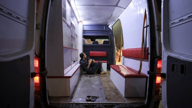 A Palestinian sits in an ambulance following an Israeli strike at a school sheltering displaced people in Gaza City on Monday.