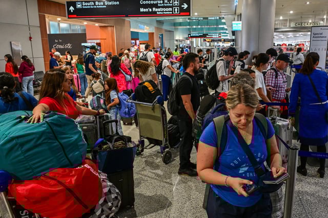 Travelers wait in line at Miami International Airport during Memorial Day weekend on May 24, 2025.