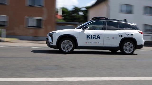Ein Fahrzeug mit der Aufschrift KIRA fährt eine Straße entlang.