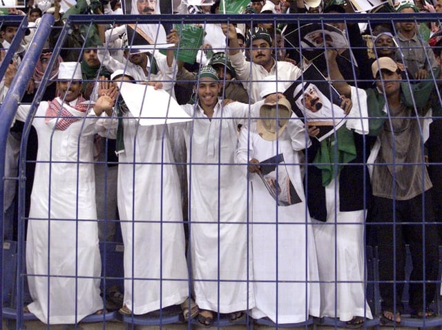 Saudi supporters wave pictures of King Fahd and of Crown Prince Abdullah during the final of the Gulf Cup tournament against Qatar in Riyadh 30 January 2002. Saudi Arabia defeated Qatar 3-1 to take the cup.      AFP PHOTO/Bilal QABALAN (Photo by BILAL QABALAN / AFP)