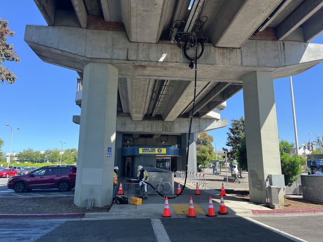Workers repair damage from the predawn explosion and fire that occurred at the San Leandro BART Station last Tuesday.