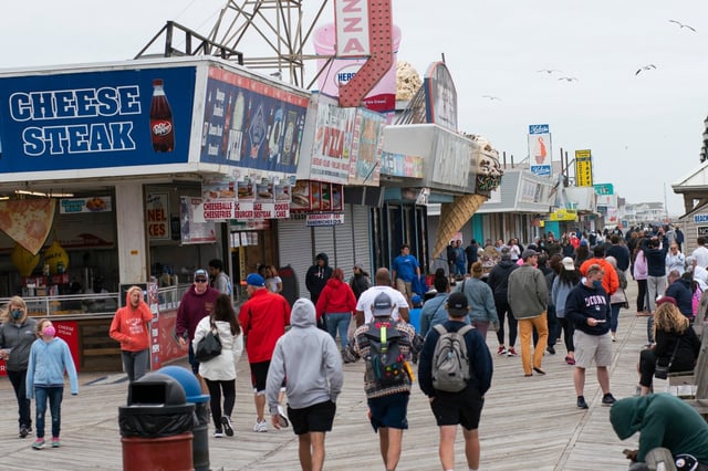 People walk on the boardwalk in Seaside Heights, New Jersey on May 24, 2020, during the Memorial Day weekend holiday. Beaches are being reopened in some coastal areas, often with bathers required to observe social distancing. The pandemic has hammered the American economy and led to a fierce debate over virus restrictions, even as COVID-19 numbers continue rising in parts of the US -- the worst-hit country in the world, with 1.6 million infections and more than 96,000 deaths. (Photo by Kena Betancur / AFP) (Photo by KENA BETANCUR/AFP via Getty Images)