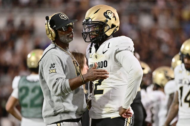 Head coach Deion Sanders of the Colorado Buffaloes talks with Shedeur Sanders #2 during the second half of a game against the UCF Knights at FBC Mortgage Stadium on September 28, 2024 in Orlando, Florida.