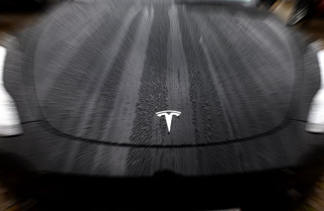 The logo of Tesla is seen on a Tesla car in Brussels, Belgium April 24, 2025. REUTERS/Yves Herman/File Photo