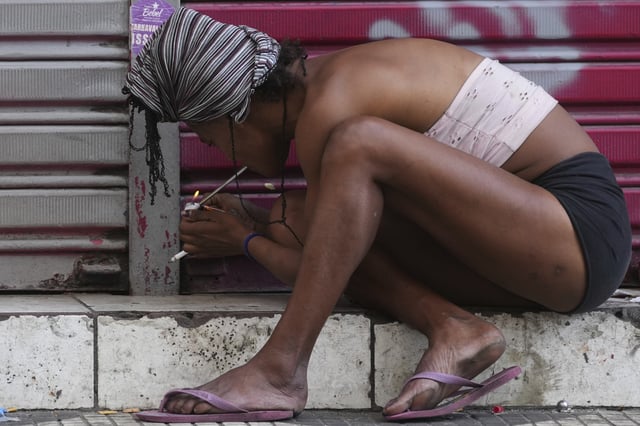 A drug addict smokes crack cocaine in a downtown area popularly known as "Crackland" in Sao Paulo, Tuesday, May 20, 2025. (AP Photo/Andre Penner)