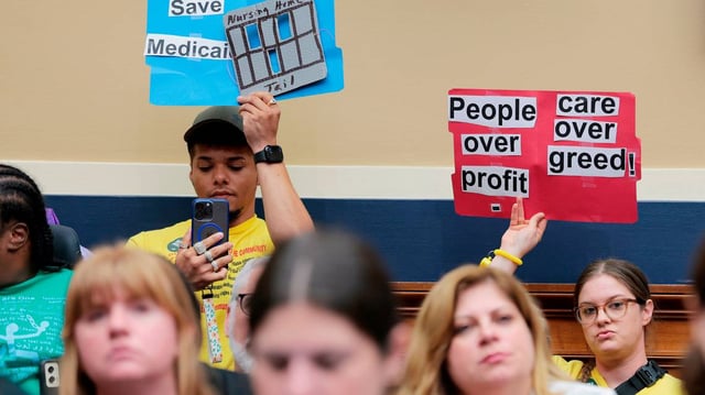 Protesters hold up signs inside of a markup meeting with the House Committee on Energy and Commerce committee on Capitol Hill on May 13, 2025, in Washington, D.C. (Anna Moneymaker/Getty Images/TNS)