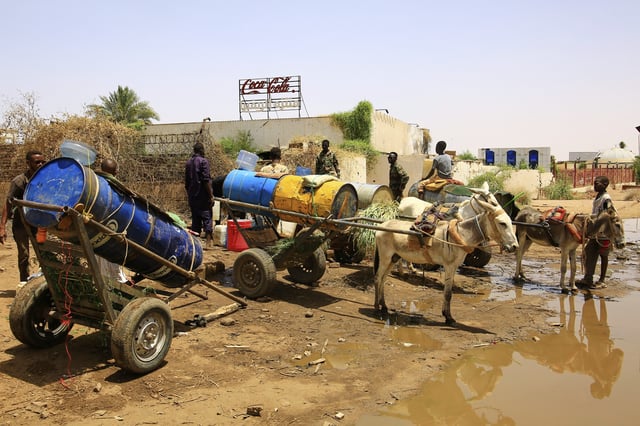 People fill water containers at a distribution point due to water outages in Khartoum, Sudan, Sunday, May 25, 2025. (AP Photo)
