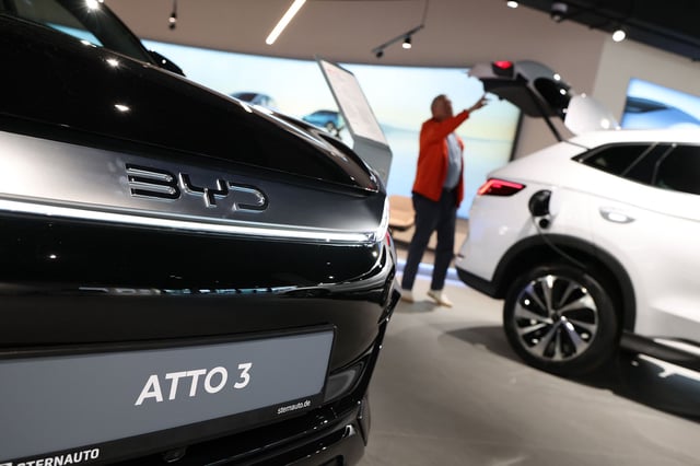A potential customer inspects Chinese carmaker BYD's electric vehicles at a dealership in May 2025 in Berlin, Germany.