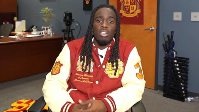 Kai Cenat in Streamer University jacket talking to camera