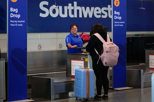 FILE - A Southwest Airlines traveler checks a bag at Midway International Airport, Tuesday, March 11, 2025, in Chicago. (AP Photo/Erin Hooley, File)