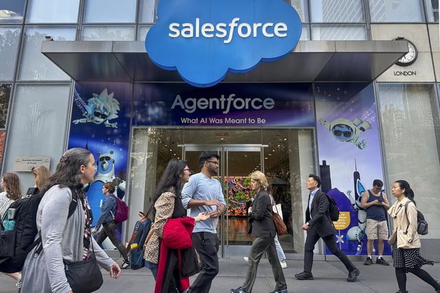 FILE - People walk past the Salesforce Tower in New York on Thursday, May 8, 2025. (AP Photo/Ted Shaffrey, File)