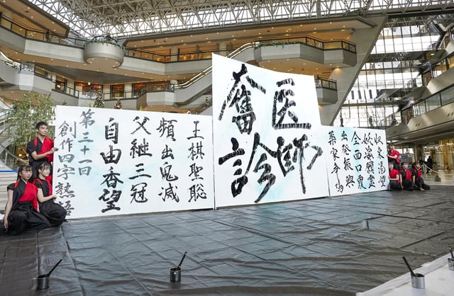 File photo of four-kanji character, taken on Dec. 22, 2020, as high school students pose following a calligraphy performance in Osaka.