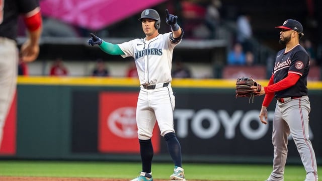 May 27, 2025; Seattle, Washington, USA;  Seattle Mariners second baseman Dylan Moore (25) celebrates at second base after hitting a double during the sixth inning against the Washington Nationals at T-Mobile Park. Mandatory Credit: Stephen Brashear-Imagn Images