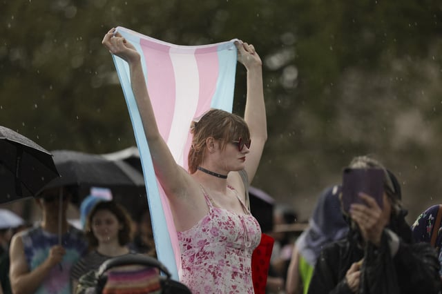 A person holds a transgender pride flag during a rainstorm at the &#39;Trans Day of Visibility Rally&#39; hosted by the Christopher Street Project on the National Mall in Washington, D.C. on March 31, 2025.