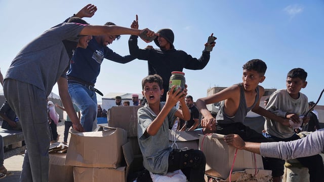 Palästinenser entnehmen in Rafah im südlichen Gazastreifen Lebensmitteln aus humanitären Hilfspaketen.