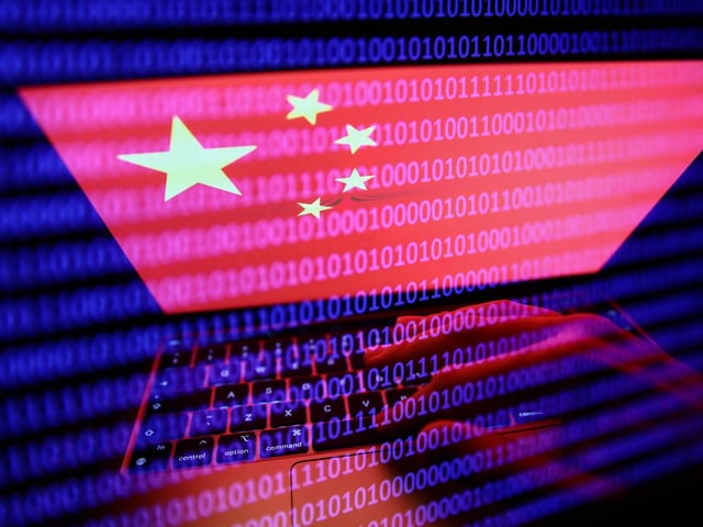 Flag of China displayed on a laptop screen and binary code displayed on a screen are seen in this multiple exposure illustration photo taken in Krakow, Poland on September 27, 2022. (Photo by Jakub Porzycki/NurPhoto via Getty Images)