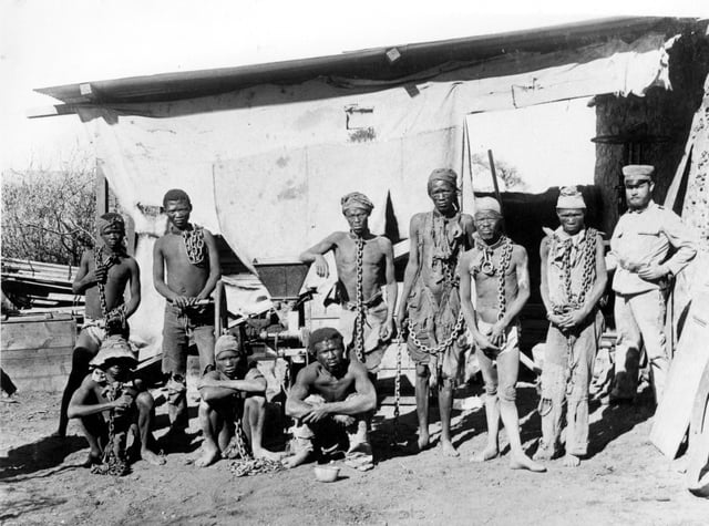 Photo non datée prise durant la guerre de l'Allemagne contre les Herreros et les Namas de Namibie (1904-1908) d'un soldat (d) appartenant probablement aux troupes allemandes gardant des prisonniers de guerre namibiens