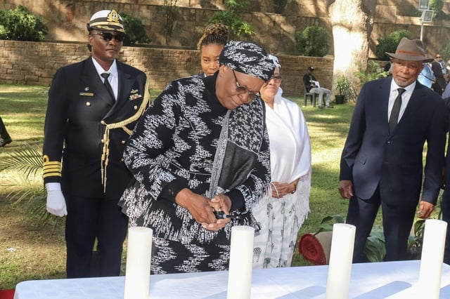 La présidente namibienne Netumbo Nandi-Ndaitwah (c) allume une bougie lors de la Journée de commémoration du génocide perpétré contre les Herero et les Nama dans les jardins du Parlement à Windhoek, le 28 mai 2025