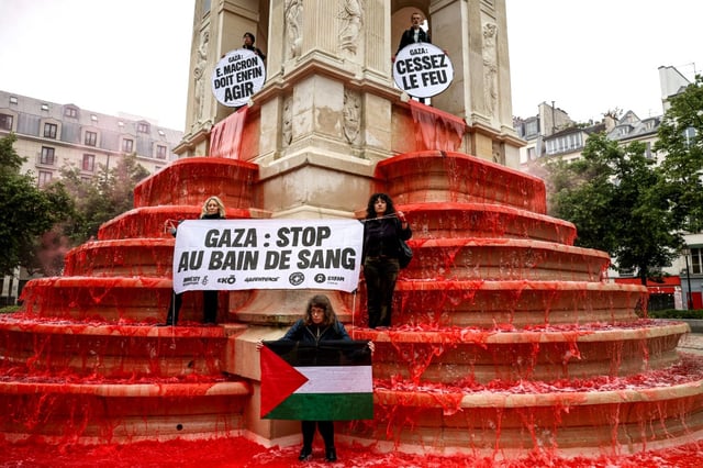 Des militants pro-palestiniens manifestent devant la Fontaine des Innocents dans laquelle des litres de colorant alimentaire rouge ont été déversés, le 28 mai 2025 à Paris