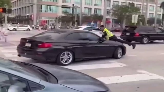 Disturbing Video Shows Miami Cop Clinging To Car Hood Before Shooting Driver Multiple Times | Image: X