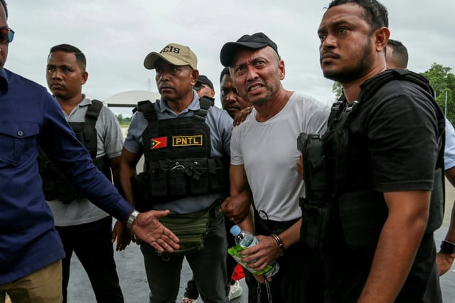 Filipino national Arnolfo Teves (2nd R), a murder suspect, is escorted by East Timorese security for deportation to his home country
