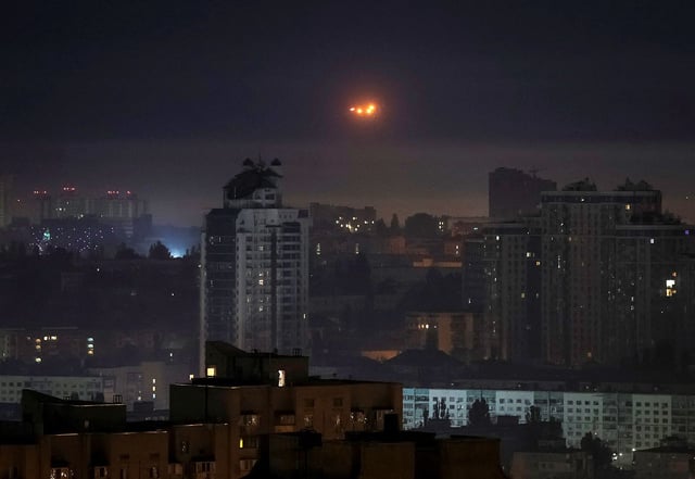 Explosions are seen in the night sky as Ukrainian servicemen fire towards drones during a Russian drone strike on May 26, 2025.