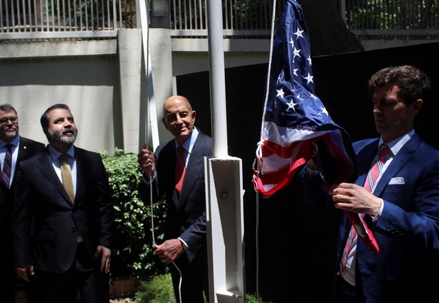 Syrian Foreign Minister Asaad Hassan al-Shibani stands next to U.S. envoy for Syria Thomas Barrack as he raises the American flag at U.S. ambassador's residency in Damascus, Syria May 29, 2025. REUTERS/Firas Makdesi