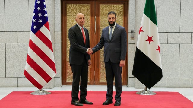 Photo diffusée par l'agence de presse officielle syrienne Sana du président syrien par intérim Ahmad al-Chareh (d) et l'envoyé spécial américain pour la Syrie, Thomas Barrack, le 29 mai 2025 à Damas