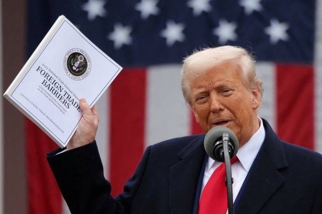 U.S. President Donald Trump holds a "Foreign Trade Barriers" document as he delivers remarks on tariffs in the Rose Garden at the White House in Washington, D.C., U.S., April 2, 2025. REUTERS/Carlos Barria/File Photo
