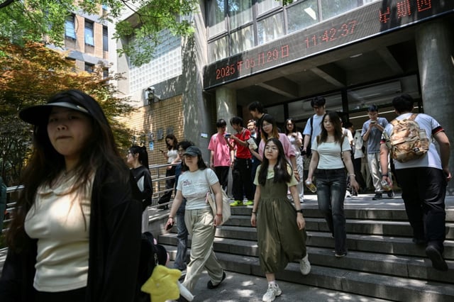 Des étudiants chinoises descendent des escaliers à l'Université des langues étrangères de Pékin (BFSU), le 29 mai 2025 à Pékin