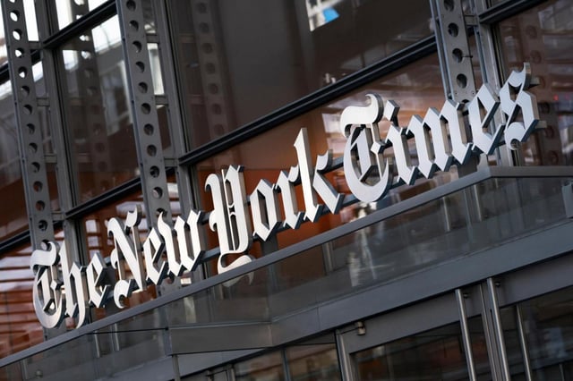FILE – A sign for The New York Times hangs above the entrance to its building, May 6, 2021, in New York. (AP Photo/Mark Lennihan, File)