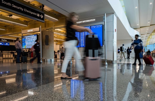Passengers walk through at Reagan National Airport at the start of the Memorial Day weekend in Arlington, Virginia on May 26, 2023. (Photo by ANDREW CABALLERO-REYNOLDS / AFP) (Photo by ANDREW CABALLERO-REYNOLDS/AFP via Getty Images)