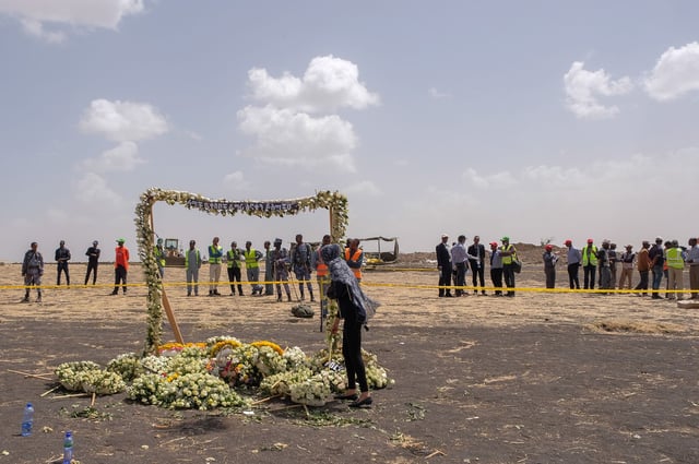 A mourner lays flowers at the Memorial Arch during a visit to the crash site of Ethiopian Airlines 737 Max flight that crashed on March 14, 2019.