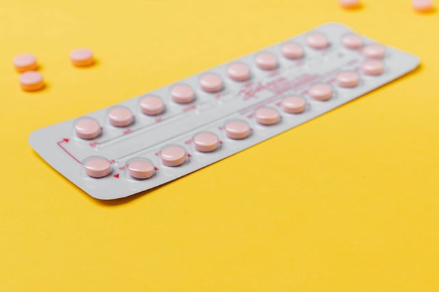 pink pills on a yellow background