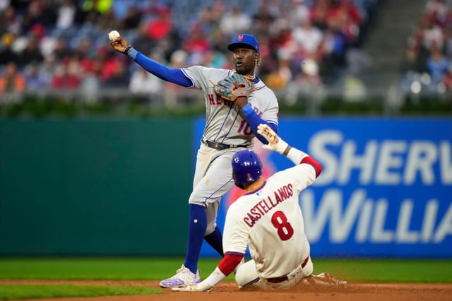 New York Mets second baseman Ronny Mauricio, left, throws to first after forcing out Philadelphia Phillies&#39; Nick Castellanos at second on a double play hit into by Edmundo Sosa during the eighth inning of a baseball game, Saturday, Sept. 23, 2023, in Philadelphia. (AP Photo/Matt Slocum)